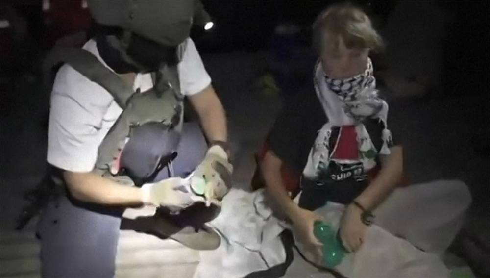 This video grab taken from a handout footage released by the Israeli Foreign Ministry on October 1, 2025 shows an Israeli soldier with Swedish climate activist Greta Thunberg (R) after several vessels of the Global Sumud Flotilla "have been safely stopped and their passengers being transferred to an Israeli port.". Israel's foreign ministry on October 1, 2025 said Israel had halted vessels from the Global Sumud Flotilla bound for Gaza, which aimed to break Israel's blockade of the Palestinian territory. (Photo by Handout / Israeli Foreign Ministry / AFP)
