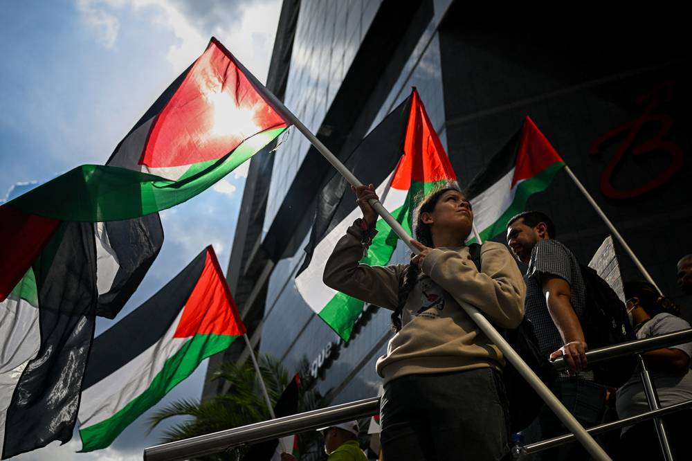 A woman holds a Palestinian flag during a protest in solidarity with Palestinians and to condemn the interception of the Global Sumud Flotilla by the Israeli army, in Caracas on Oct 2. Photo by Federico Parra/AFP