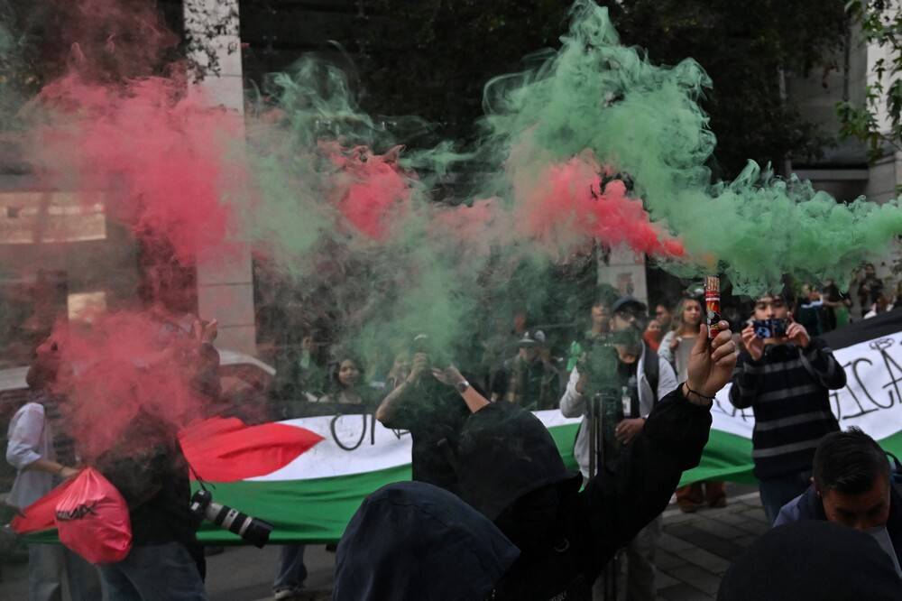 Demonstrators hold smoke flares in the colors of the Palestinian flag during a protest in solidarity with Palestinians and to condemn the interception of the Global Sumud Flotilla by the Israeli army in Bogota, on Oct 2. Photo by Raul Arboleda/AFP