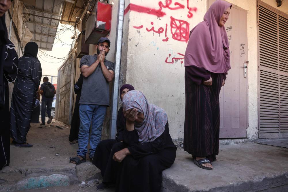 Palestinians mourn the death of loved ones killed in Israeli strikes, outside al-Aqsa Martyrs hospital in Deir el-Balah in the central Gaza Strip, on October 1, 2025. (Photo by BASHAR TALEB / AFP)