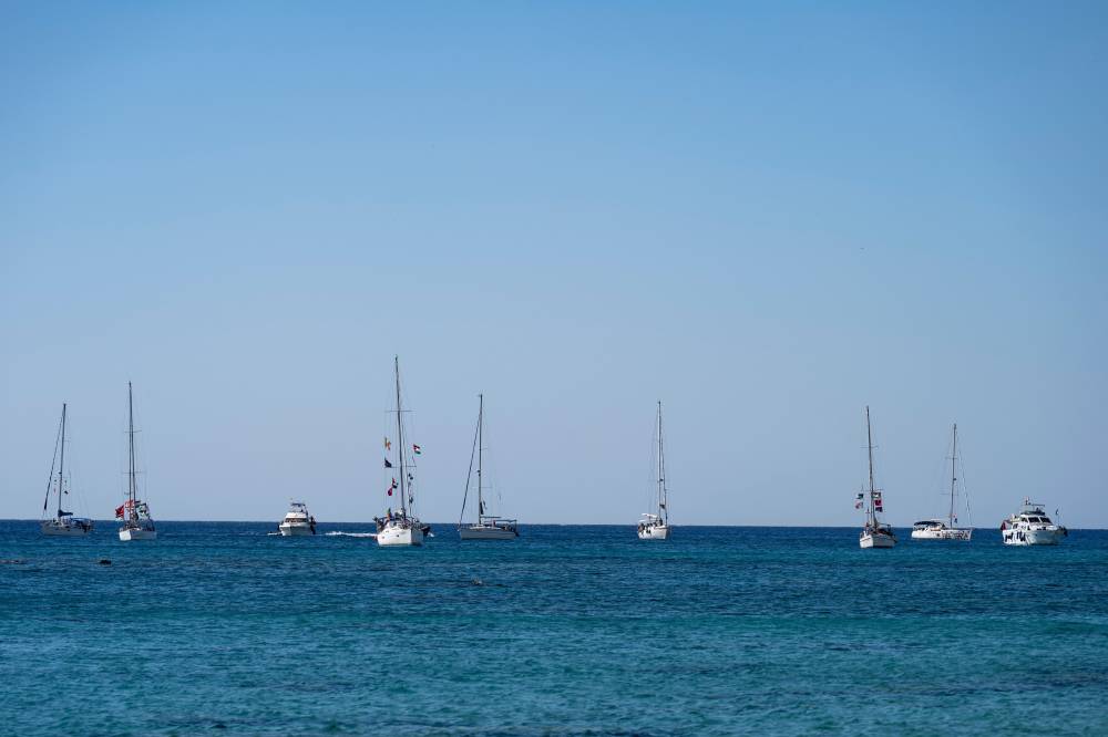 A group of ships of the Global Sumud Flotilla to Gaza are shown moored at the small island of Koufonisi, south of the island of Crete on September 26, 2025. (Photo by Eleftherios ELIS / AFP)