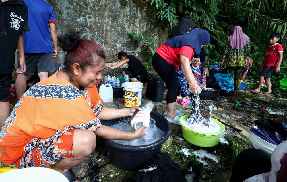 Photo from Sandakan, Sabah on Sept 16 shows residents of Kampung Sim Sim are forced to use hill water to wash clothes after the district's clean water supply was disrupted. The crisis worsened after the Segaliud water treatment plant lost power on Sept 13, crippling supply from the Sabah Water Department. (BERNAMA PHOTO)
