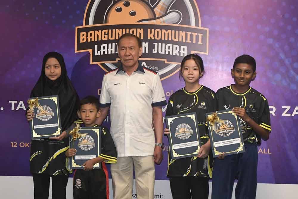 Mohd Annuar (centre) presenting a certificate of participation to a student representative.