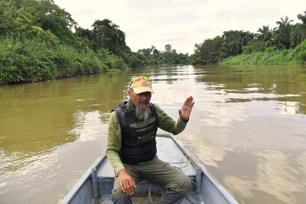 (FILE PIX) Environmental activist Ahmad Nizar Kamaruddin from Sahabat Alam Malaysia observes riverbank erosion caused by oil palm cultivation along Sungai Kinta near Kampung Permatang Pelandok in Pasir Salak, saying smallholders often encroach buffer zones to maximise land use on Sept 27, 2025. (BERNAMA PHOTO) 