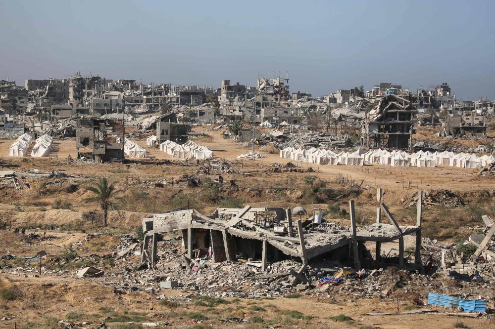 Tents erected amid destroyed buildings in the in al-Zahra area, north of the Nuseirat refugee camp in the central Gaza Strip, on Oct 14, 2025, a day after a ceasefire came into effect. Photo by Eyad Baba/AFP