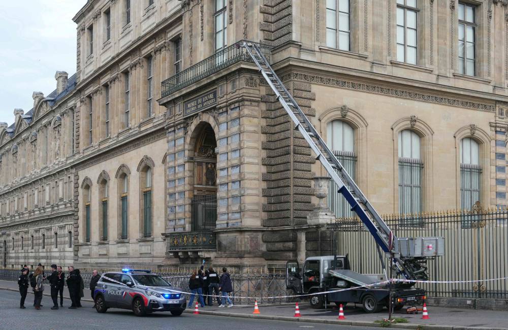 French police officers stand next to a furniture elevator used by robbers to enter the Louvre Museum, on Quai Francois Mitterrand, in Paris on October 19. Photo by Dimitar Dilkoff/AFP
