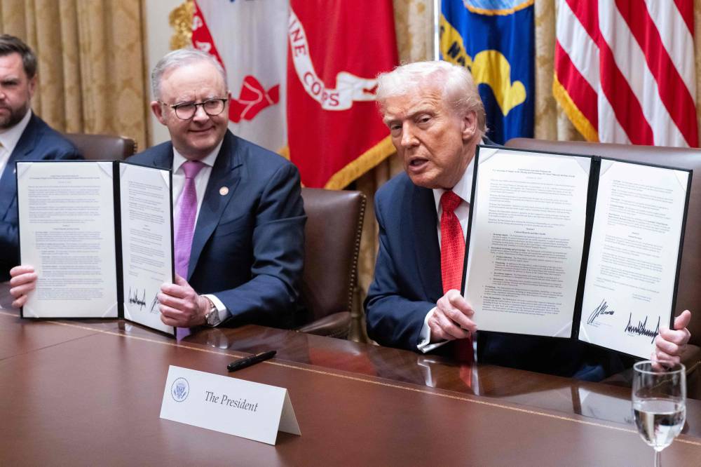 US President Donald Trump (right) and Australia's Prime Minister Anthony Albanese display an agreement on critical minerals they signed in the Cabinet Room at the White House in Washington. Photo by Saul Loeb/AFP