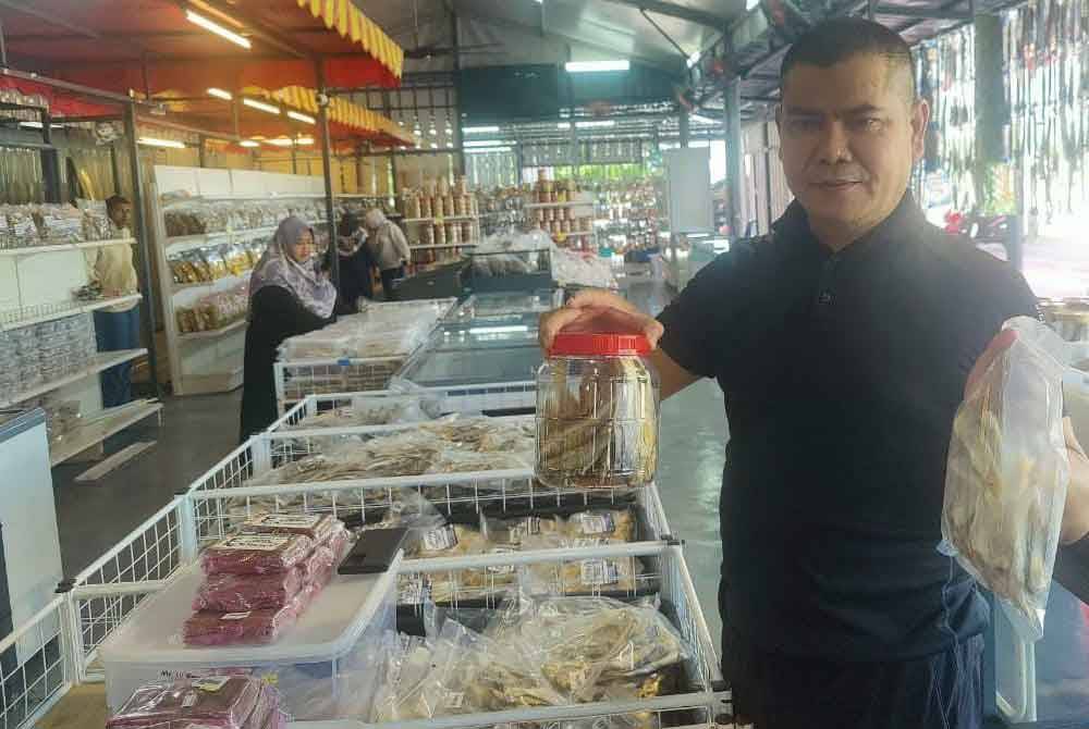 Jamal showcases various types of salted fish sold at the collection centre in Kampung Sungai Leman.