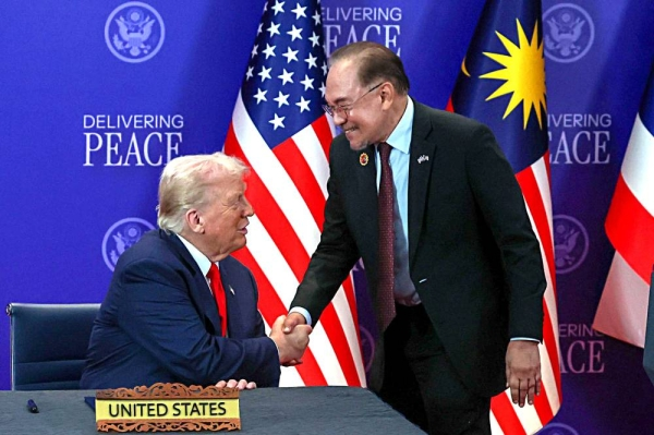 United States President Donald Trump and Malaysian Prime Minister Datuk Seri Anwar Ibrahim share an elated and proud moment as they shake hands at the signing of the Cambodia-Thailand peace deal during the 47th ASEAN Summit today. Photo: Bernama