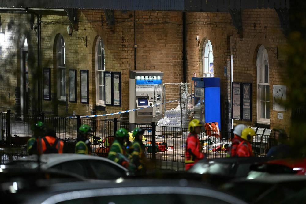 Emergency workers pass a Police cordon outside Huntingdon Station in Huntingdon, eastern England, on Nov 1, 2025, following a stabbing on a train. - (Photo by JUSTIN TALLIS / AFP)