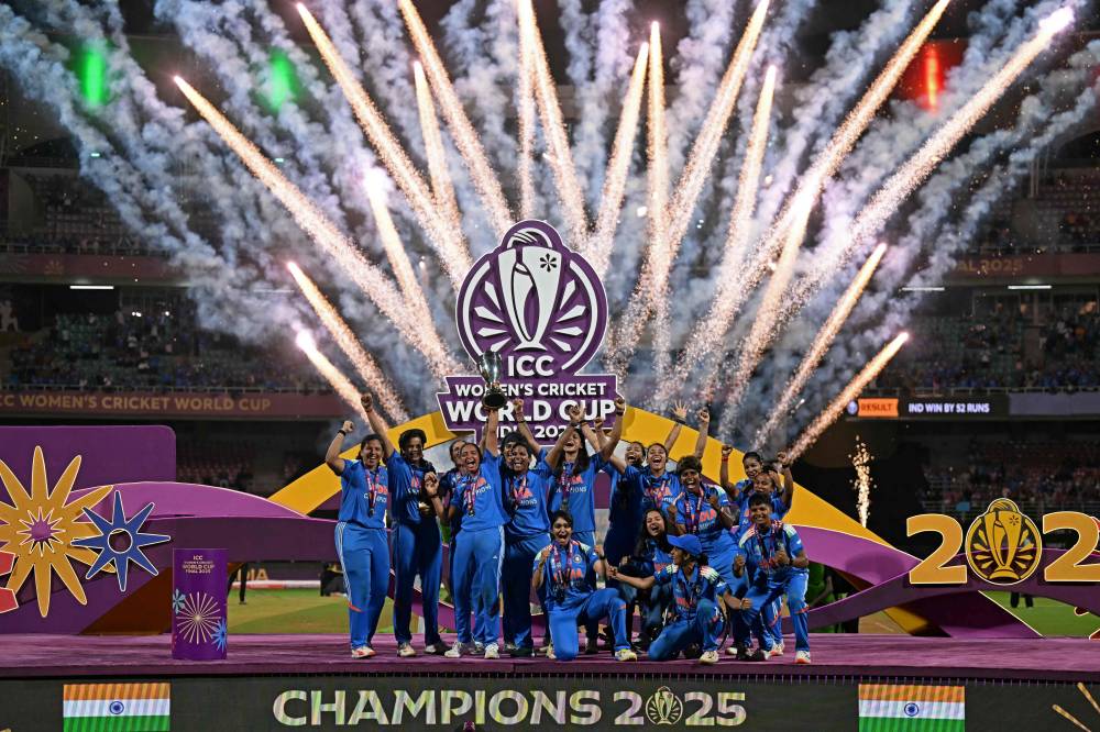 India’s players celebrate with the trophy after winning the ICC Women's Cricket World Cup 2025 one-day international (ODI) final match between India and South Africa at the DY Patil Stadium in Navi Mumbai on November 3, 2025. (Photo by Punit PARANJPE / AFP)