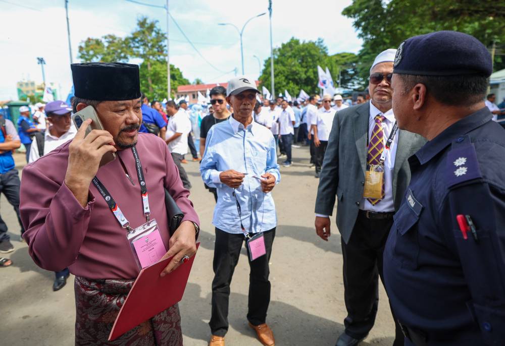 SPP candidate for the Sulabayan state seat Abdul Hata Abdul Hala (left), failed to submit his nomination papers after arriving at the Semporna Community Arena Hall Nomination Centre past 10am during the 17th Sabah state election, today. - Photo by Bernama