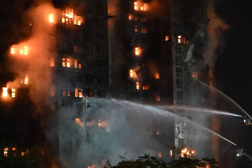 Firefighters spray water during a major fire at the Wang Fuk Court residential estate in Hong Kong's Tai Po district. Photo by Peter Parks/AFP