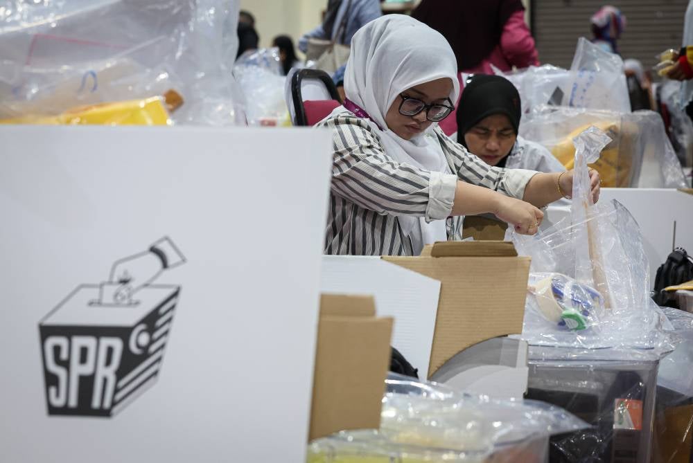 EC personnel checking the ballot boxes for the upcoming 17th Sabah state election at Dewan Seri Sulaman, today. - Photo by Bernama