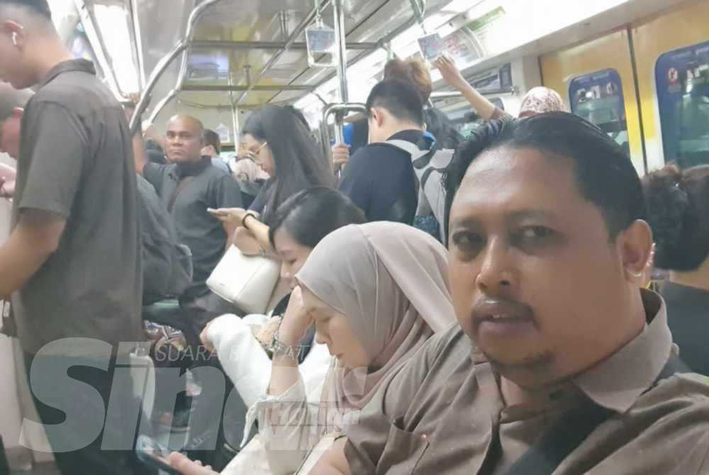 Sinar Harian Reporter Izwan Rozlin (right) observing the morning crowd inside a Kuala Lumpur Monorail train.