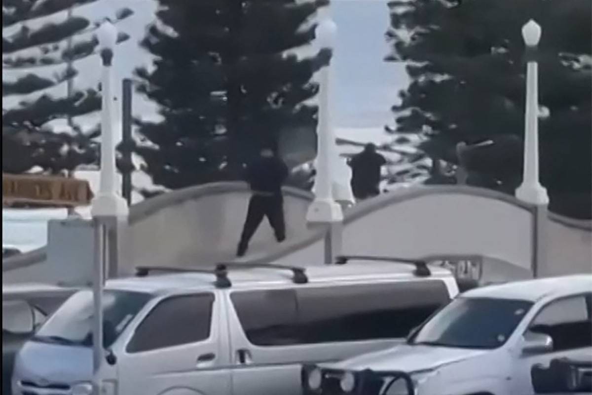 This screen grab made from UGC handout video footage courtesy of Timothy Brant-Coles shows two gunmen dressed in black firing multiple shots on a bridge at Bondi Beach in Sydney. Photo by Handout /various sources/AFP