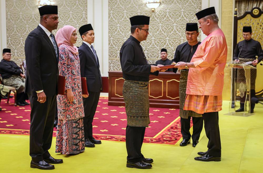 Yang di-Pertuan Agong Sultan Ibrahim presented the instrument of appointment to Economy Minister Akmal Nasrullah Mohd Nasir. Photo by Bernama 