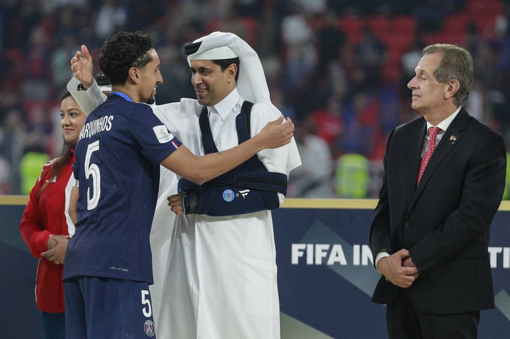 Paris Saint-Germain's Brazilian defender #05 Marquinhos is congratulated by Paris Saint Germain's Qatari president Nasser al-Khelaifi after winning the 2025 FIFA Intercontinental Cup final football match between Paris Saint-Germain (PSG) and CR Flamengo at the Ahmad bin Ali Stadium in Al-Rayyan on the outskirts of Doha on December 17, 2025. (Photo by Karim JAAFAR / AFP)
