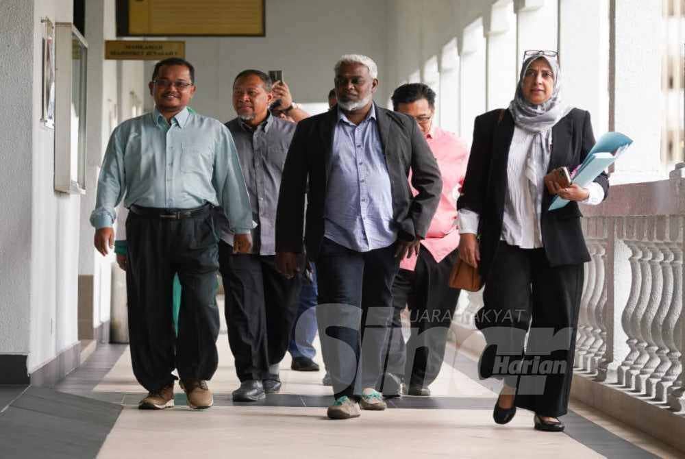 Zaharudin (left) with supporters and lawyer Latheefa (right) arrives at the Kuala Lumpur magistrate’s court on Monday. Photo – ROSLI TALIB/SINAR