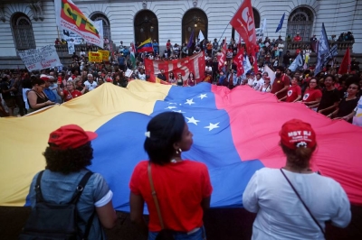 People display a giant Venezuelan flags as they take part in a demonstration in support of Venezuela's President Nicolas Maduro at the Cinelandia square in Rio de Janeiro, Brazil, on Jan 5, 2026, after US forces captured the Venezuelan leader. - (Photo by MAURO PIMENTEL / AFP)