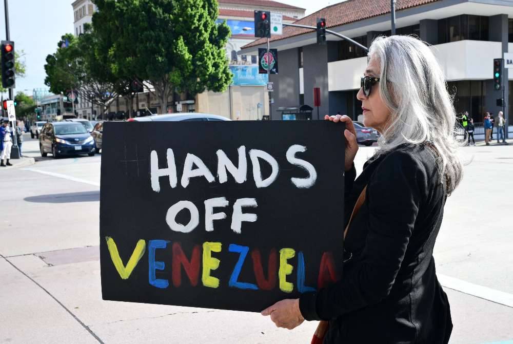 Activists gather to protest against US President Donald Trump's recent action in Venezuela on Jan 6, 2026 in Pasadena, California, calling on Congress for an immediate end to military action, accountability for President Trump's actions and diplomacy over war. - (Photo by Frederic J. Brown / AFP)
