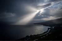 A ray of sun shines through clouds over Lake Geneva next to the Lavaux vineyard terraces near Chexbres, western Switzerland, on August 8, 2018. (Photo by Fabrice COFFRINI / AFP)