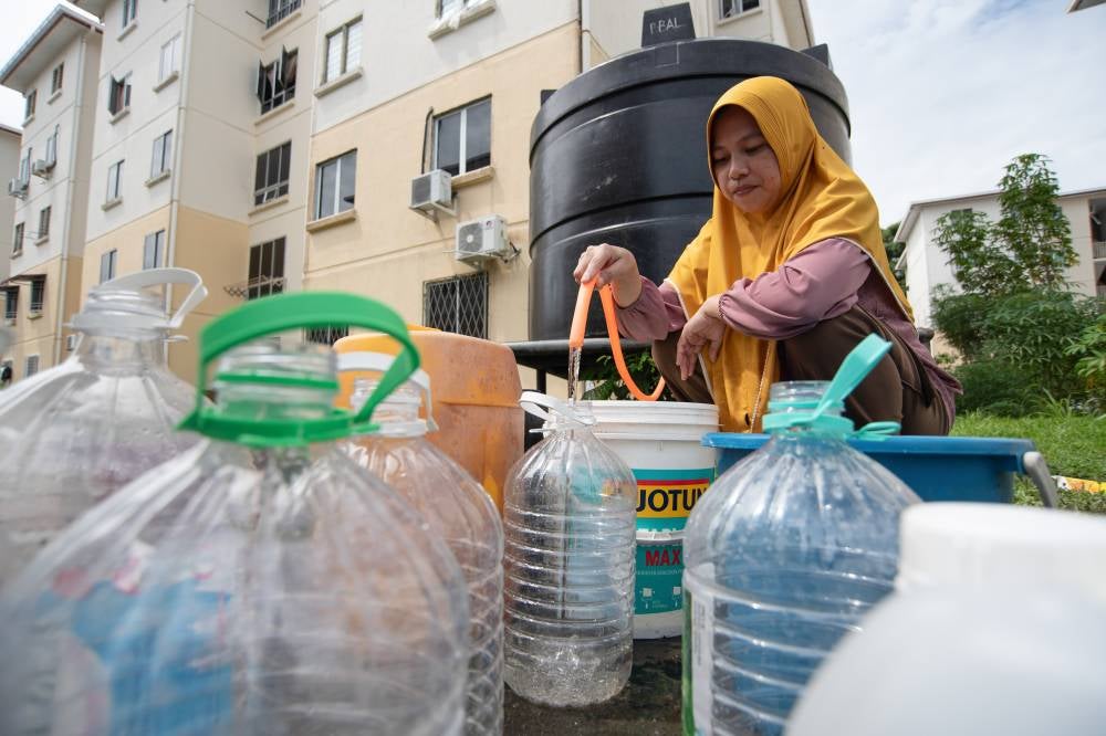 Housewife, Farida, 35, collects water from a static water tank provided to meet her family’s daily needs at the Taman Mutiara Sungai Bedaun area. Several villages and residential areas here, affecting more than 10,000 consumers, have been grappling with interrupted water supply since Jan 9, 2026, adding strain on households at the start of the school term. - Bernama photo