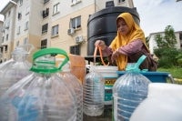 Housewife, Farida, 35, collects water from a static water tank provided to meet her family’s daily needs at the Taman Mutiara Sungai Bedaun area. Several villages and residential areas here, affecting more than 10,000 consumers, have been grappling with interrupted water supply since Jan 9, 2026, adding strain on households at the start of the school term. - Bernama photo