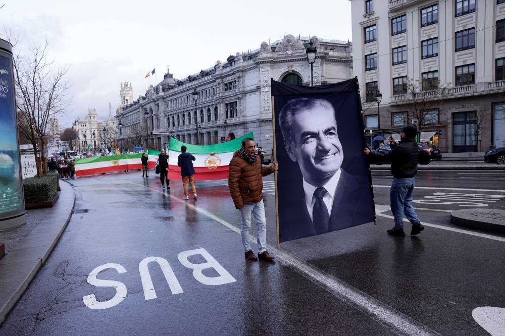 Protestors hold a portrait of the last shah of Iran Mohammad Reza Pahlavi during a demonstration in support of Iranian People in Madrid on January 17, 2026. Human-rights groups say Iranian authorities are carrying out their most severe repression in years of protests under the cover of a more than five-day internet blackout. (Photo by Oscar DEL POZO / AFP)