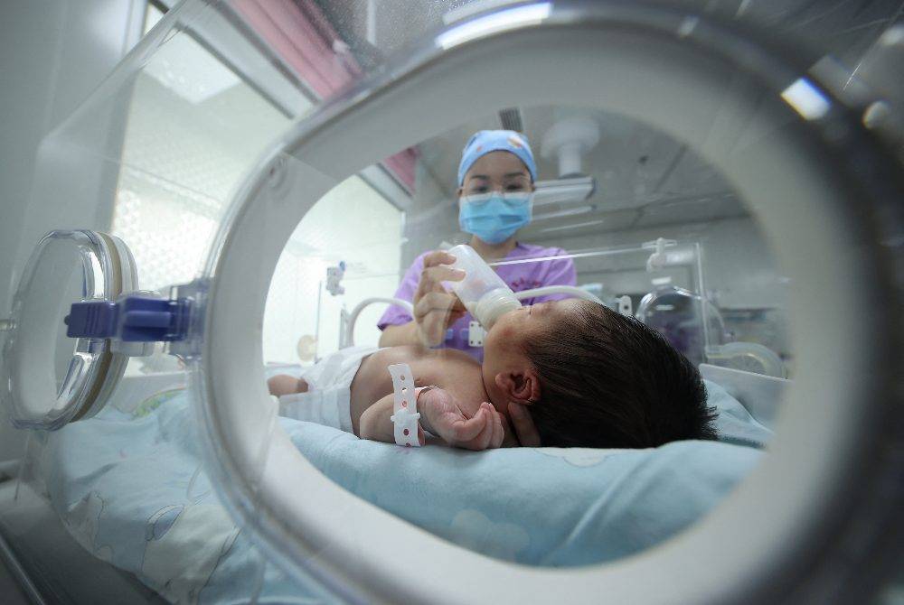 A medical staff member feeds a baby at a hospital in Danzhai in China's southwestern Guizhou province on May 11, 2021. - (Photo by AFP)