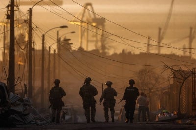 Chilean soldiers patrol among the damage after a wildfire in Concepcion, Chile on Jan 18, 2026. - (Photo by RAUL BRAVO / AFP)