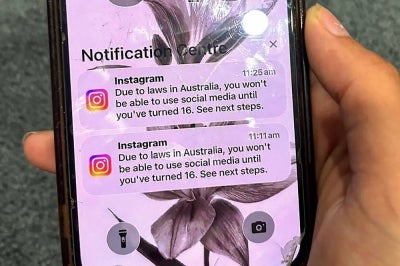 A teenager holds a mobile phone displaying a message from social media platform Instagram after the account was locked for age verification in Sydney on December 9, 2025. (Photo by AFP)