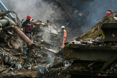 Rescue workers search amid the debris after a massive fire at a shopping mall in Karachi. Photo by Asif Hassan/AFP