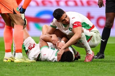 Morocco's defender #02 Achraf Hakimi (R) checks his teammate defender #25 Adam Masina after being injured during the Africa Cup of Nations (CAN) final football match between Senegal and Morocco at the Prince Moulay Abdellah Stadium in Rabat on January 18, 2026. (Photo by FRANCK FIFE / AFP)