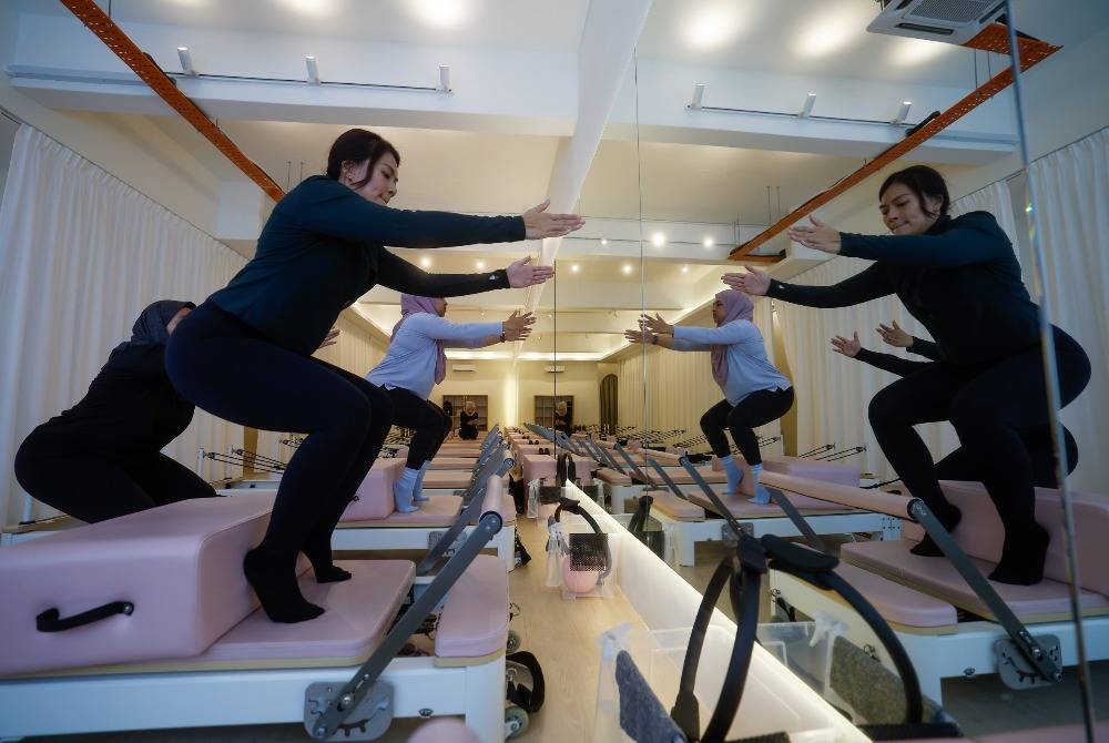 Dr Nur Rafidah Mohamed Ali and Ili Izzati Setu perform stretching and Pilates exercises during a recent visit to the Pilates Collective studio. Photo by Bernama