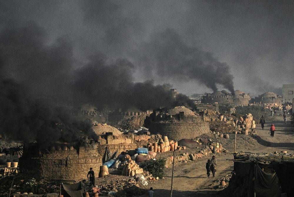 This photograph taken on Jan 10, 2026 shows smoke billowing from kilns at a potters' colony in Karachi. - (Photo by ASIF HASSAN / AFP)