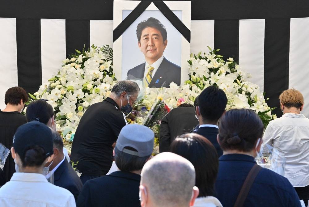 This photo taken on Sept 27, 2022 shows people offering their respects to former Japanese prime minister Shinzo Abe outside the Nippon Budokan in Tokyo, ahead of his state funeral later in the day. Photo by Yuichi Yamazaki/AFP FILE PIX