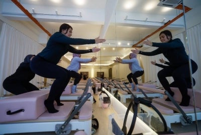Dr Nur Rafidah Mohamed Ali and Ili Izzati Setu perform stretching and Pilates exercises during a recent visit to the Pilates Collective studio. Photo by Bernama