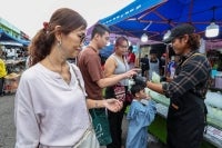 Razzuan Rosli, 35, (right), who is fluent in Mandarin, attends to customers purchasing avocado juice when met by Bernama at the Johor Jaya night market recently. - Bernama photo