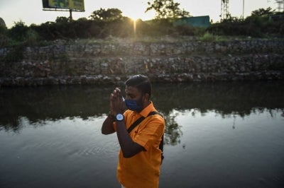 A Hindu devotee performs a religious ritual ahead of the Thaipusam festival outside a temple in Batu Caves on the outskirts of Kuala Lumpur on January 17, 2022. (Photo by Arif Kartono / AFP)