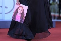 A guest holds a portrait of late Palestinian girl Hind Rajab during the red carpet for the movie "The Voice of Hind Rajab" presented in competition at the 82nd International Venice Film Festival, at Venice Lido on Sept 3, 2025. Photo by Tiziana Fabi/AFP