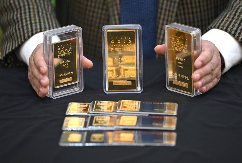 An employee displays gold bars at a store of the Korea Gold Exchange in Seoul on January 26, 2026. (Photo by Jung Yeon-je / AFP)