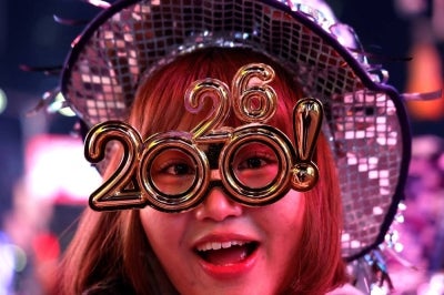 A reveler poses as she celebrates New Year's Eve in Times Square on Dec 31, 2025 in New York. (Photo by John Lamparski / AFP)