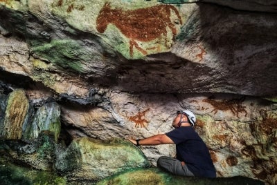 Researchers have discovered slender stenciled hands with deliberately elongated, claw-like fingernails in the caves of Sulawesi, in the oldest example of rock art in the world, dating back 67,800 years. - Courtesy of Griffith University's Maixme Aubert/AFP