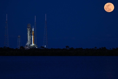 A full moon rises as the Space Launch System (SLS) rocket and the Orion spacecraft, integrated for the Artemis II mission, are seen at Launch Pad 39B at the Kennedy Space Center in Cape Canaveral, Florida, on February 1, 2026 ahead of the first crewed mission to the Moon in more than 50 years. (Photo by Miguel J. Rodriguez Carrillo / AFP)