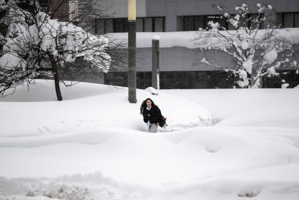 A woman walks near a snow-covered bus terminal in Aomori city, Aomori prefecture on Jan 30, 2026. - (Photo by PHILIP FONG / AFP)