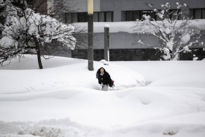 A woman walks near a snow-covered bus terminal in Aomori city, Aomori prefecture on Jan 30, 2026. - (Photo by PHILIP FONG / AFP)