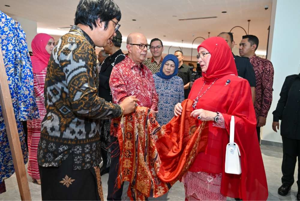 Tengku Ampuan Pahang Tunku Azizah Aminah Maimunah Iskandariah visits a booth at the launch of the Minggu Seri-Ibu Kraf CIMB, accompanied by CIMB Group chairman Datuk Syed Zaid Albar. - Photo courtesy of CIMB