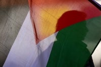 A silhouette of a demonstrator is seen behind a Palestinian flag during a protest in solidarity with Palestinians and to condemn the interception of the Global Sumud Flotilla by the Israeli army in Bogota on Oct 2, 2025. - (Photo by RAUL ARBOLEDA / AFP)