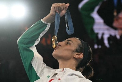 Gold medallist Algeria's Imane Khelif poses on the podium during the medal ceremony for the women's 66kg final boxing category during the Paris 2024 Olympic Games at the Roland-Garros Stadium, in Paris on Aug 9, 2024. - (Photo by MOHD RASFAN / AFP)
